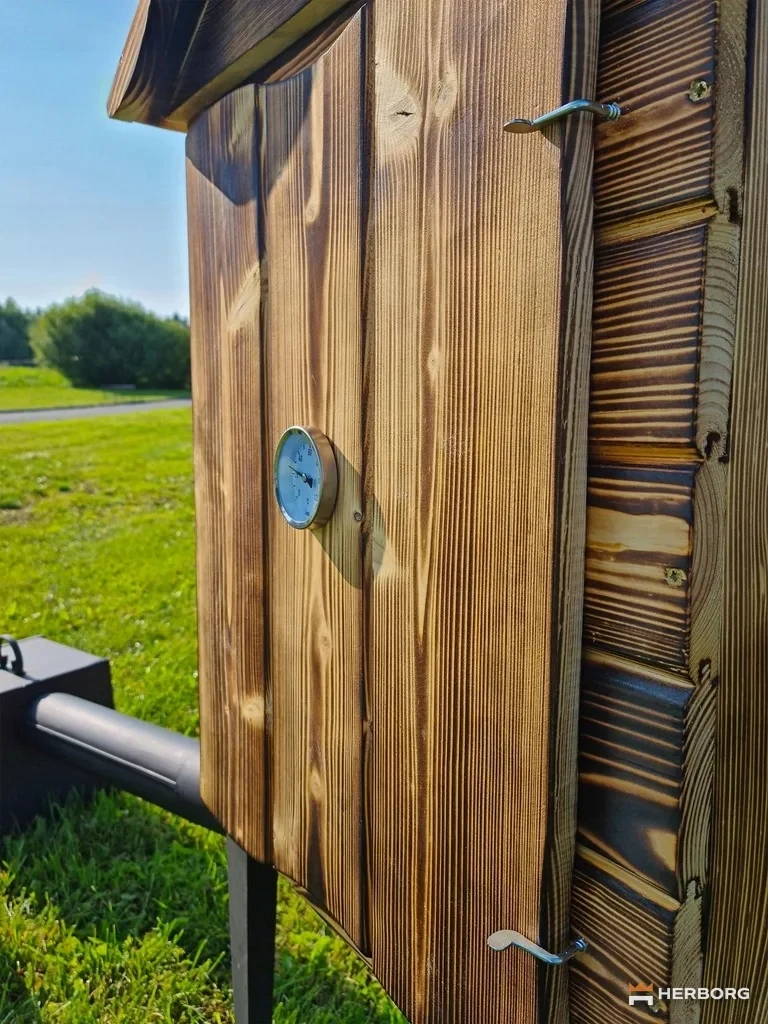 Zbliżenie opalanych desek, zamknięcia drzwi i termometru wędzarni EH-092OP – HERBORG